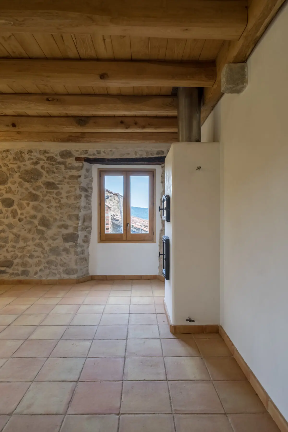 Finestra oberta al mur de pedra d’una masia rehabilitada